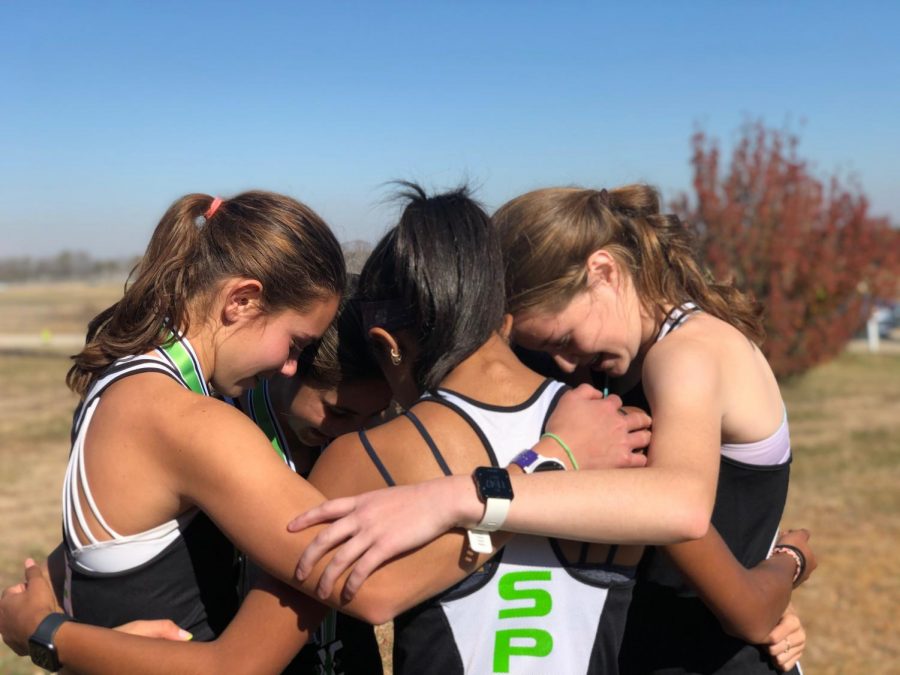 The+Girls+Cross+Country+Team+gather+for+one+last+team+huddle+after+finishing+their+final+race+of+the+season
