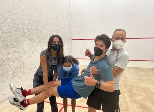 Squash team members Ria Parekh, Mehak Dey-Kohli, and Daniel Braun with Coach Sanchez.