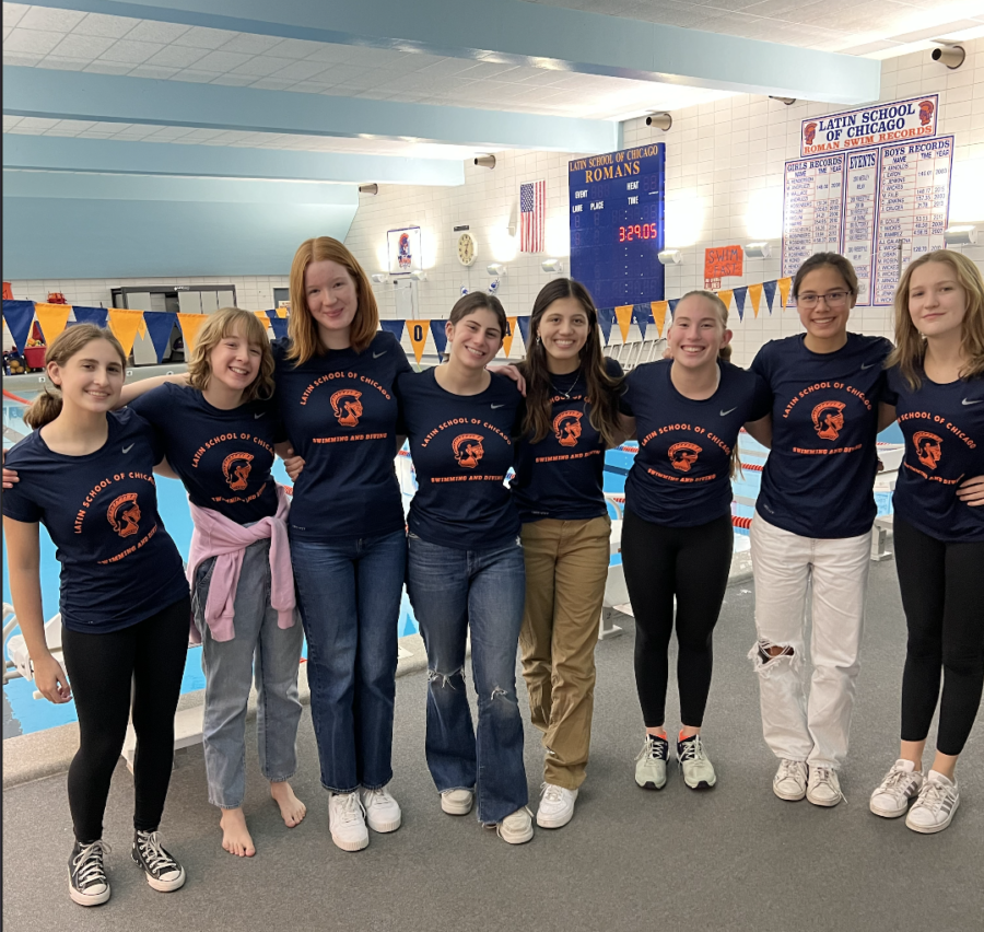 The girls swim team, one of Latins aquatics programs, stands by the Greg Baker pool.