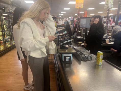 Sophomore Kate Weiskirch using her phone to buy a tea at Potash.