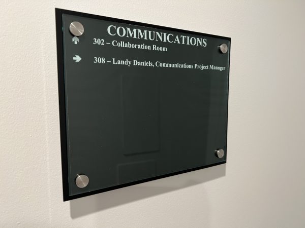 The plaque outside of the Communications Office has only one staff member listed: Landy Daniels.