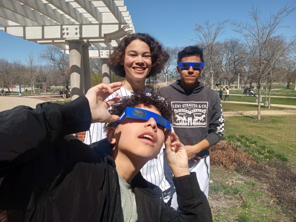 Sophomores Justin Canelo and Diego Fernandez pose in their eclipse glasses alongside junior Will Behan