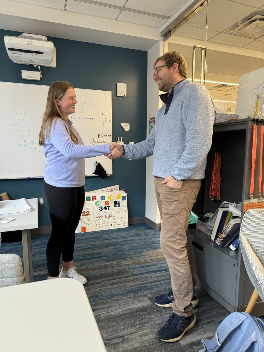 Upper School math teacher Zach McArthur and seventh place winner Maggie Zeiger shake hands after another year of a successful Masters Pool.