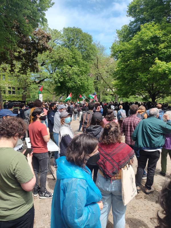 Protestors holding Palestinian flags gather outside the University of Chicago. 