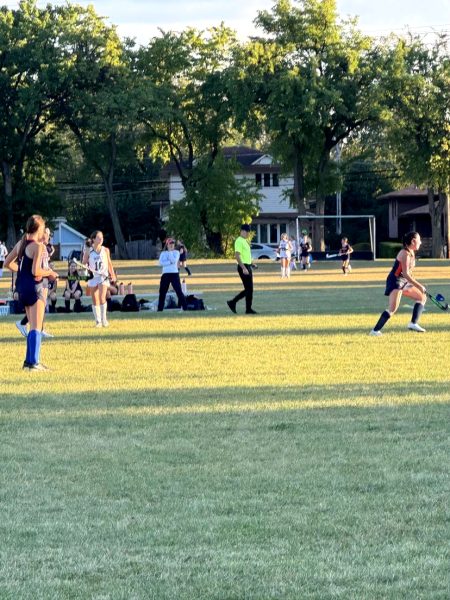 Latin's JV field hockey team pacing across a field at Glenbard West.