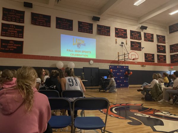 Student-athletes and their families gather in the Field Gym to watch a video of season highlights compiled by Latin parents.