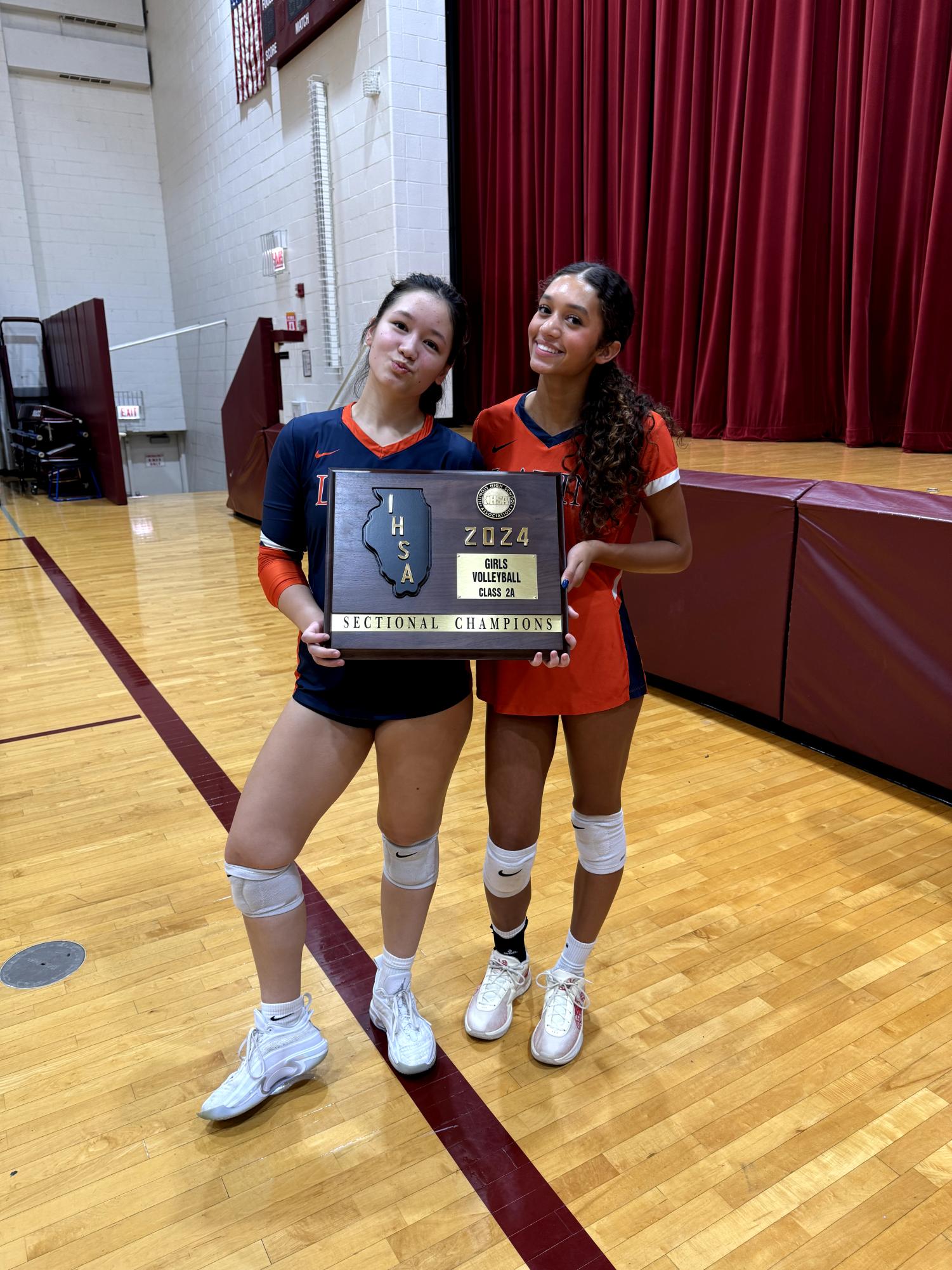 Juniors Avery Hellweg (left) and Peyton Remmer after winning the IHSA 2A girls volleyball sectionals.