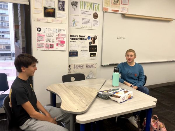 Junior Gillian Herman (right) and sophomore Theo Garino in discussion during affinity time.