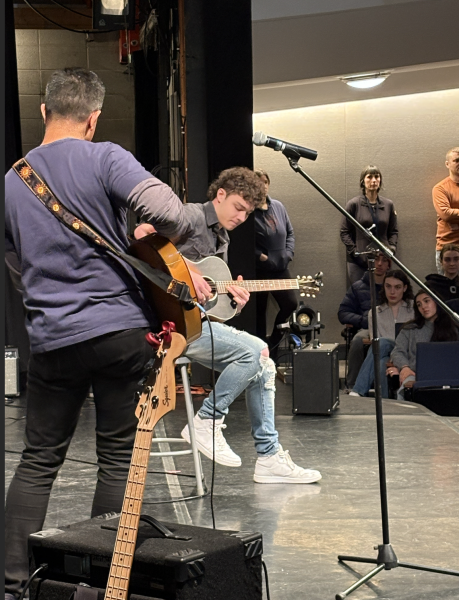 Richard Heller '24 plays guitar while Bobby Oommen sings.