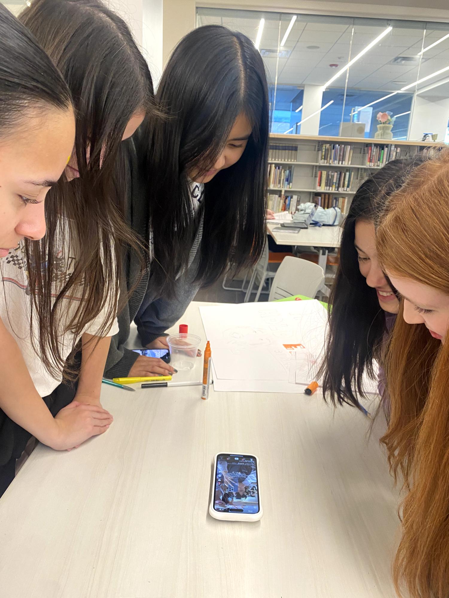 Seniors sharing a TikTok video in the Learning Commons.