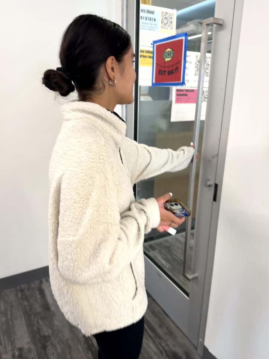 Student attempting to open locked door between the quiet area of the Learning Commons and the fourth floor Kiosk.