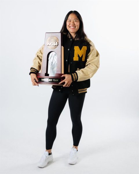 Helen Hu displays the University of Missouri's third-place team trophy from the NCAA gymnastics national championships.