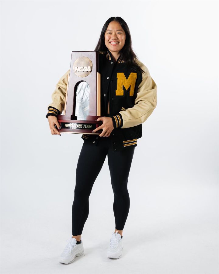 Helen Hu displays the University of Missouri's third-place team trophy from the NCAA gymnastics national championships.