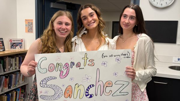 Seniors Carla McSweeney, Tatum Kamin, and Maddy Levy display a poster they made with their advisory to congratulate the fourth graders 