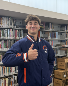 Senior Drew Lufrano gives a thumbs up while wearing a Latin jacket.