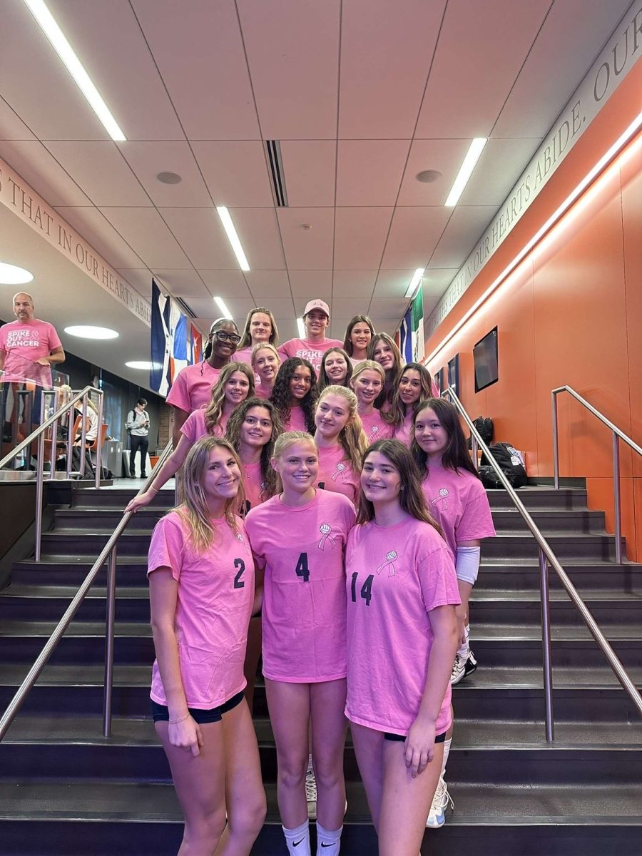 Latin volleyball players pose in their pink jerseys before their pink-out game in honor of Breast Cancer Awareness Month.