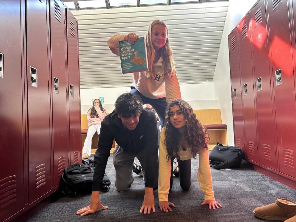 Freshmen Louisa Rose (top), Sara Kapur (bottom right), and Rohan Theis (bottom left) form a pyramid to represent the hierarchies discussed in "Worlds Together, Worlds Apart."