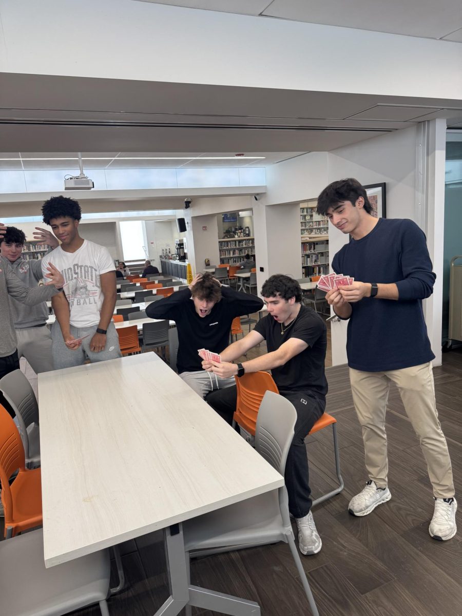 Seniors react to a crazy card hand in the Learning Commons.
