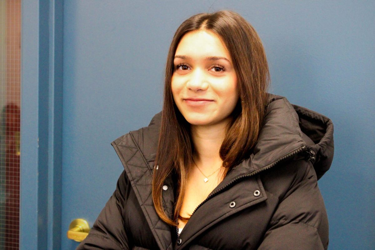 Senior Mira Wojno smiles in her matte black Super Puff jacket.