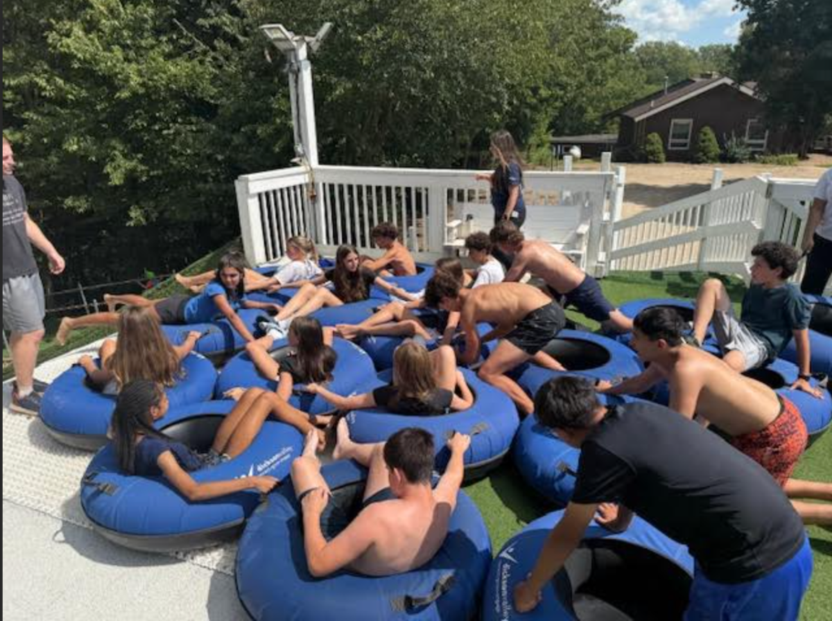 Freshmen push each other down a slide in inner tubes during the overnight retreat at Dickson Valley.