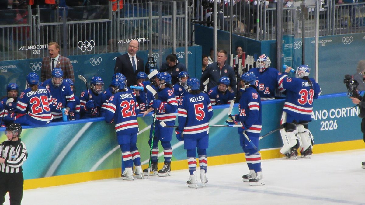 The U.S. Women’s Hockey Team reconvenes at the bench for a TV timeout during the quarterfinal match against Italy.