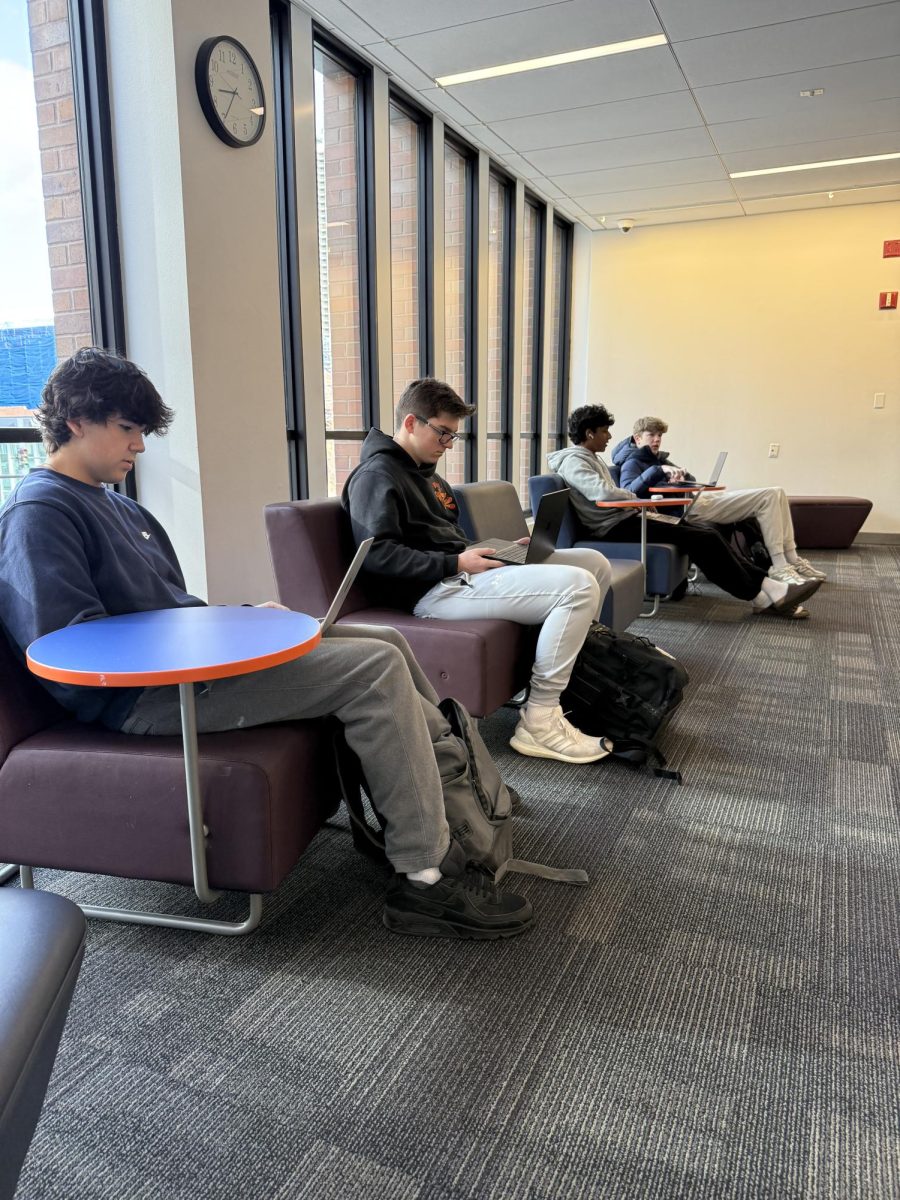 Row of students looking down at their laptops