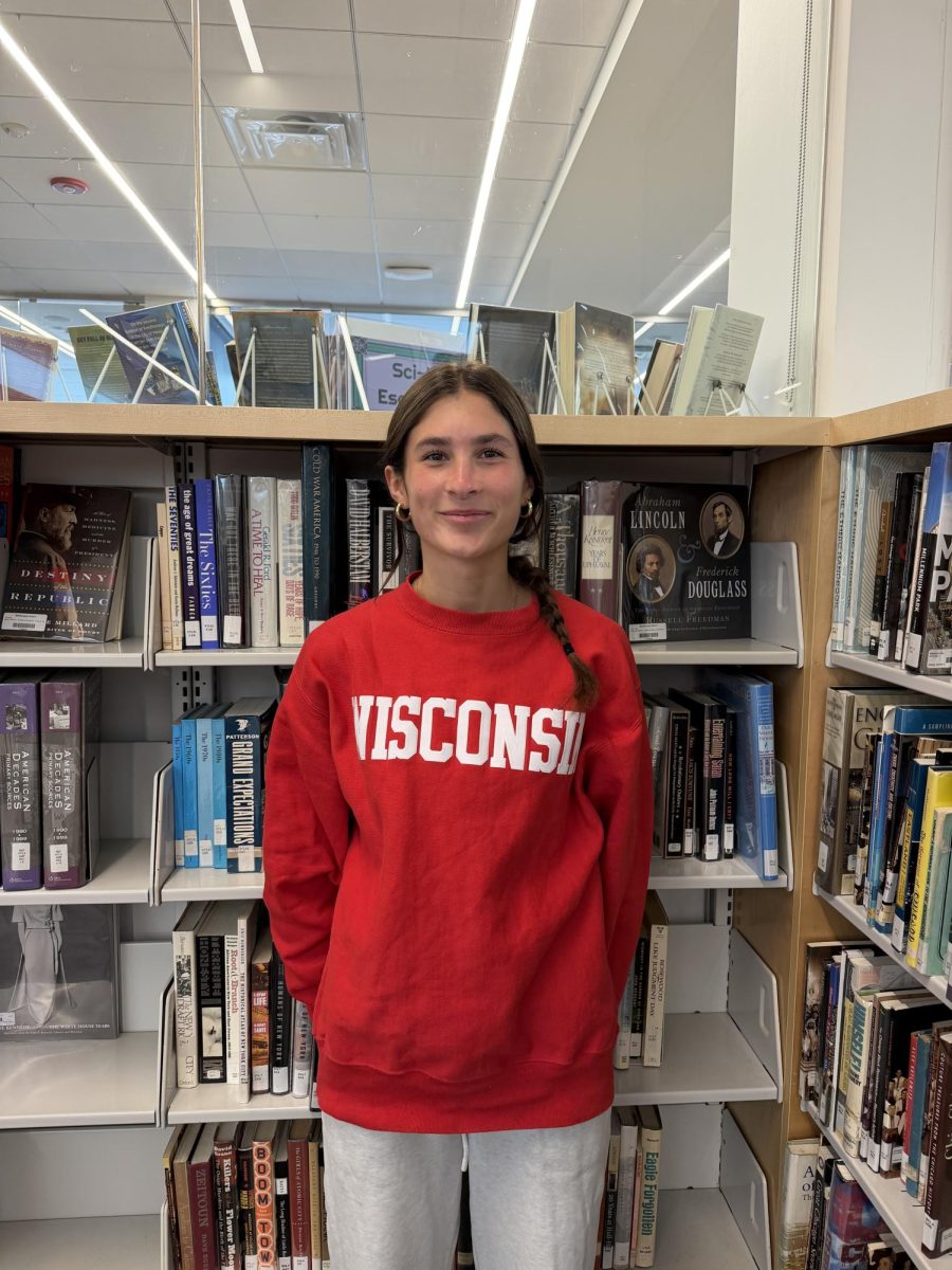 Senior Teagan Moroney stands by the books in the Learning Commons.