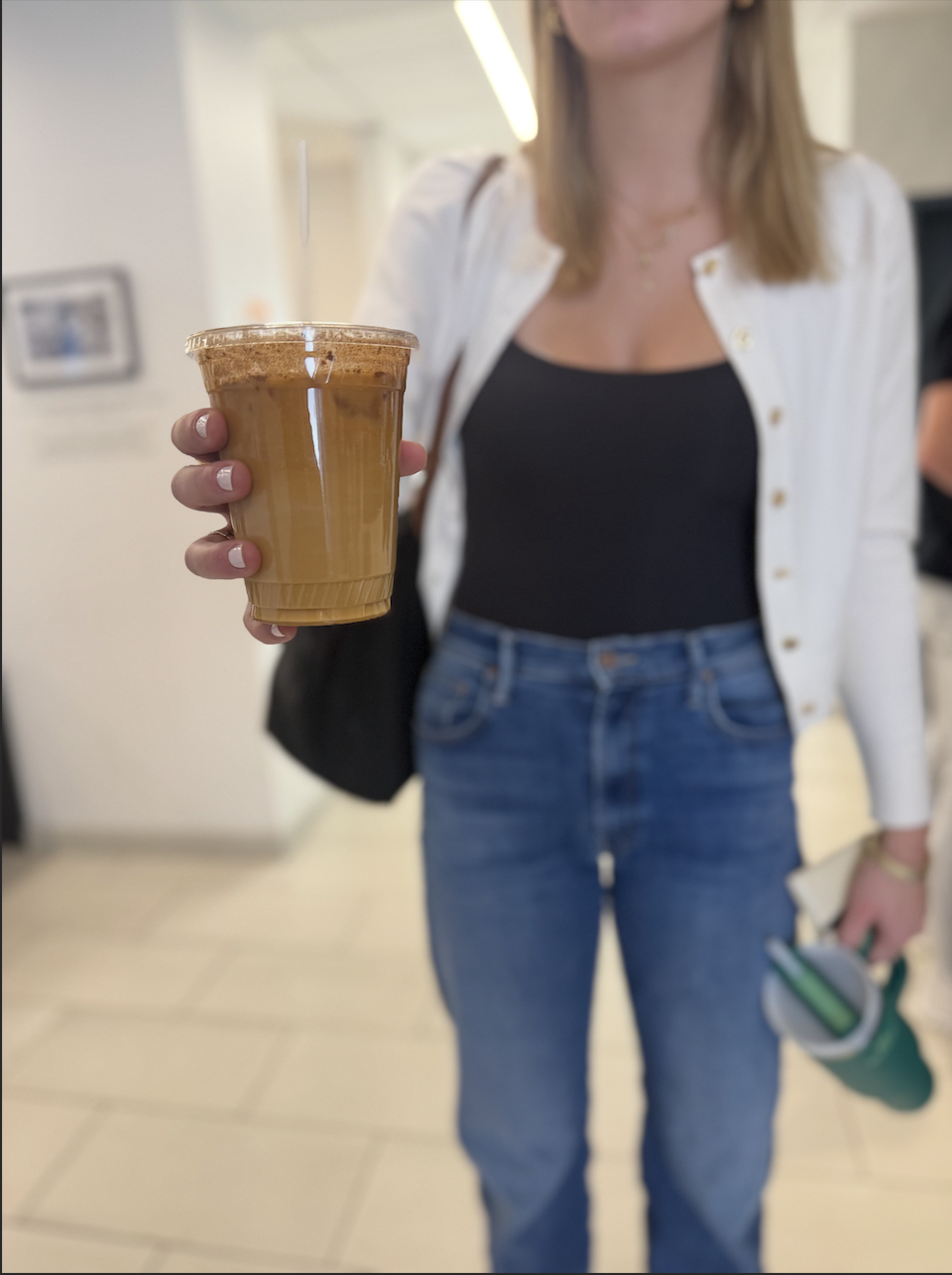 Senior Ellie Szczerba shows the latte she orders from the Upper School kiosk.
