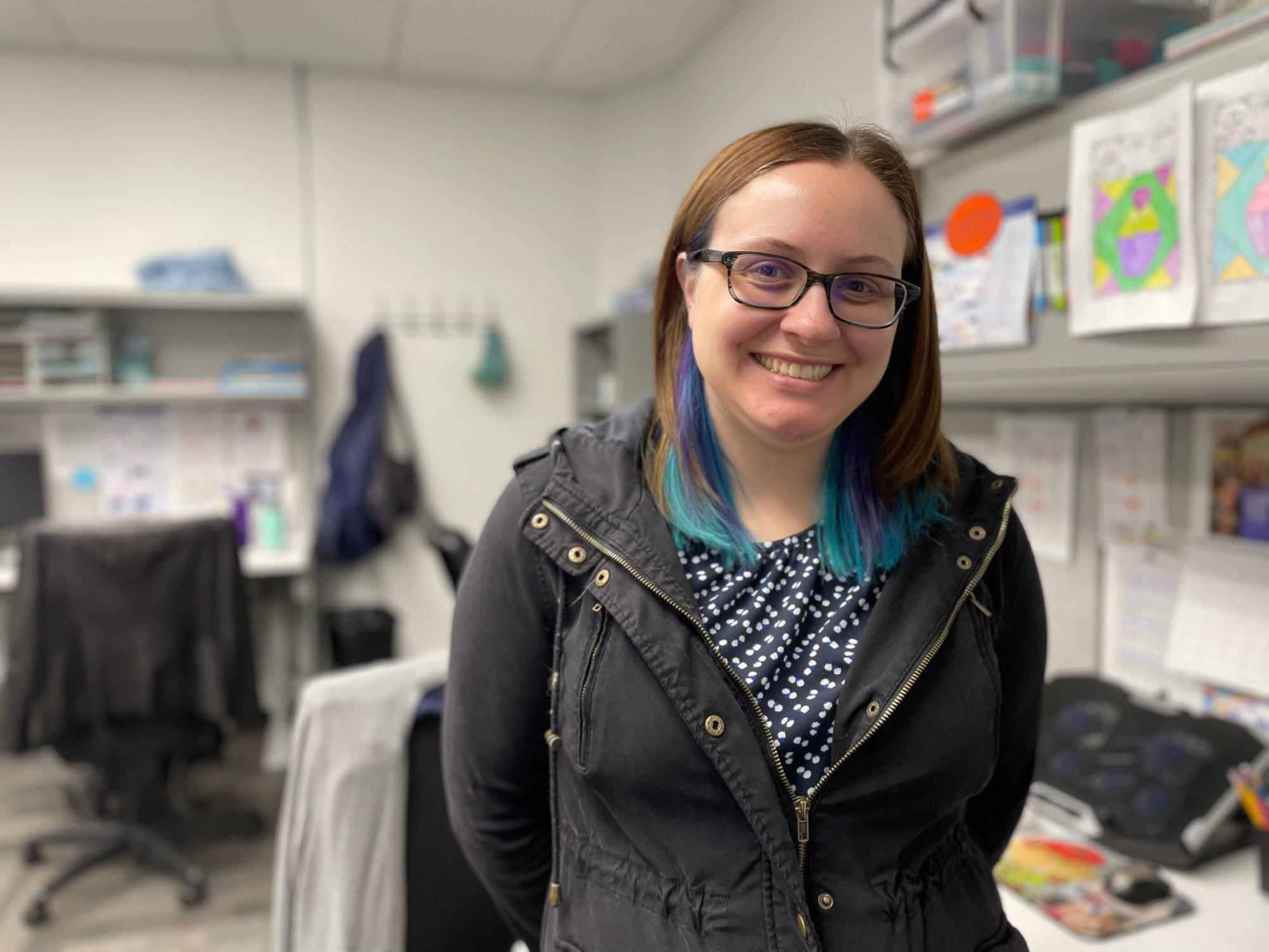 Freddie Swinson smiles in front of her desk in the Upper School Math Center.