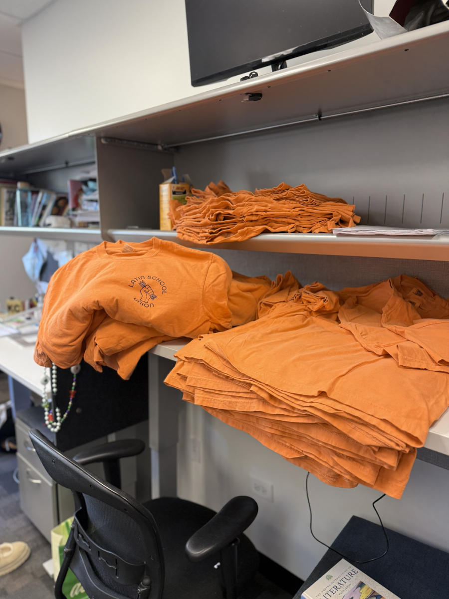 Latin School Union shirts sit folded in stacks in the English office.