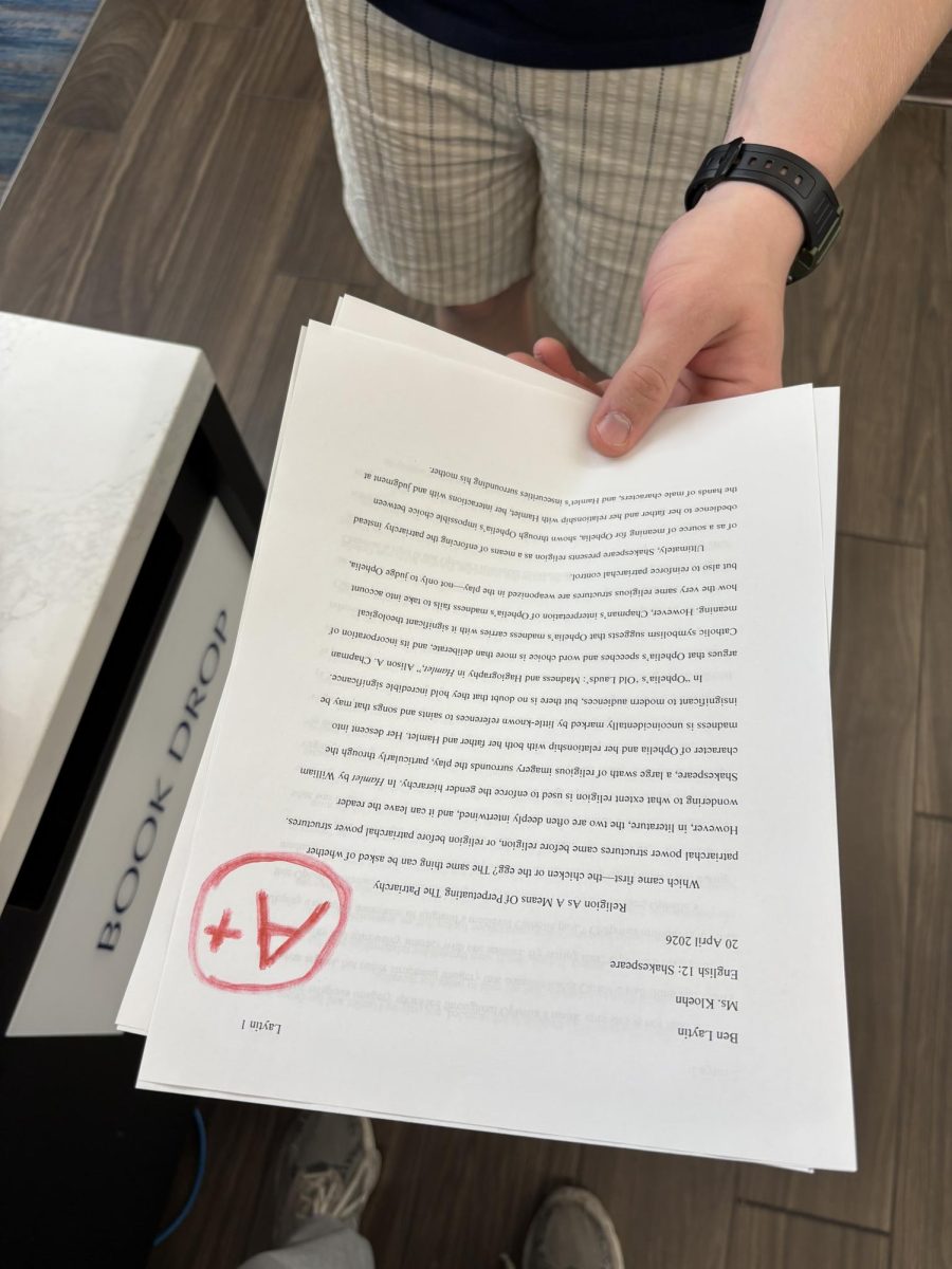 A student looks at a fake grade on his real paper
